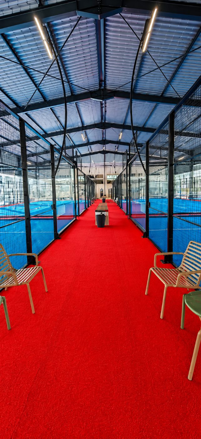 Allée rouge desservant les terrains de padel couverts du club Jungle Padel